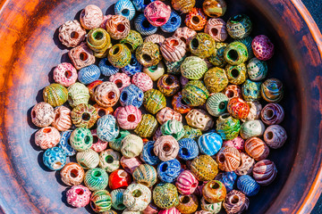 Fototapeta na wymiar Colorful beads in a earthen dish