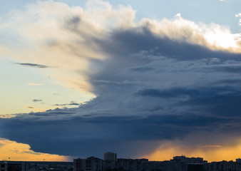 Stormy supercell weather over the city at sunset.