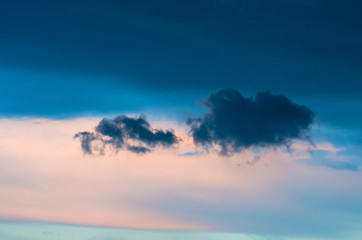 Lonely gray clouds in the dark evening sky.