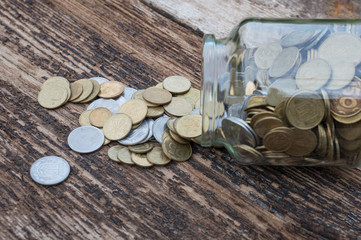 Ukrainian coins in a jar on a wooden background