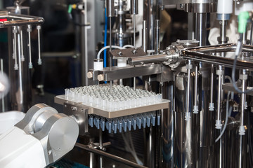 Sterile bottles and ampoules on the dispensing line, medical laboratory equipment