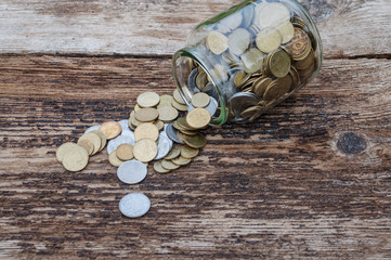 Ukrainian coins in a jar on a wooden background