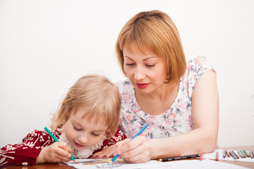 Young mom and her little daughter drawing