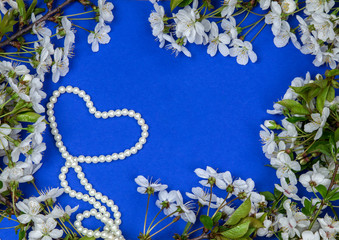 Blue background with cherry flowers and necklace of pearls