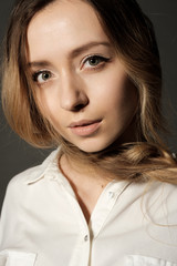 Naklejka premium Closeup portrait of a young girl blonde looking into the camera