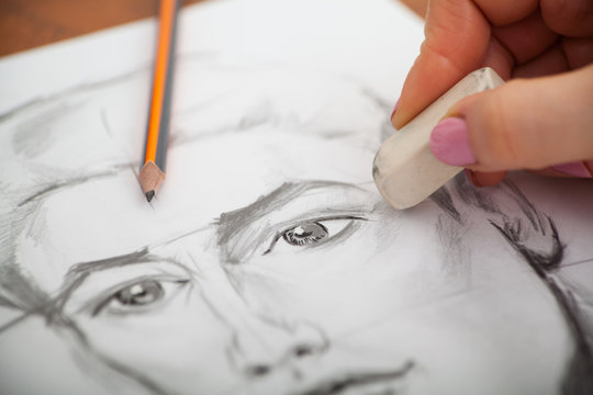 Closeup of drawing man's portrait at the desk
