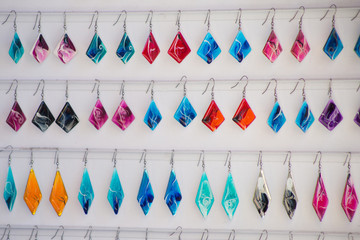 Many colored earrings on a white background. Concept of sales