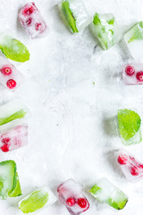 mint and red berries in ice cubes stone background top view mockup