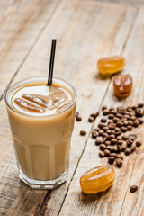 coffee ice cubes and beans with latte on wooden desk background