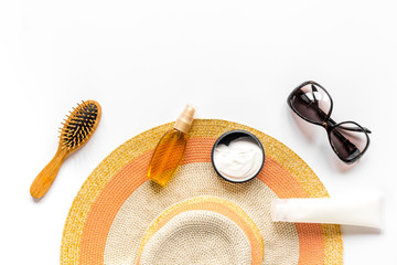 Sun protection composition with glasses and cream on white background top view mockup