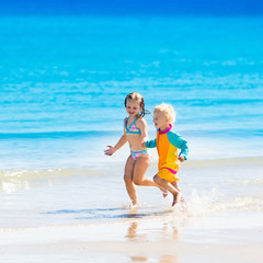 Naklejka premium Kids run and play on tropical beach
