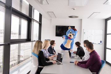 boss dresed as bear having fun with business people in trendy office