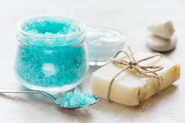 Home cosmetic with cream and blue sea salt on stone background