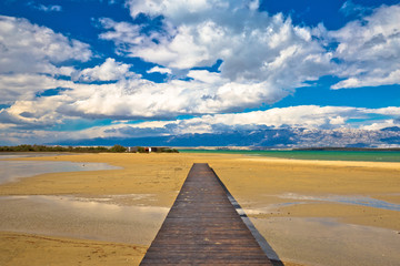 Fototapeta na wymiar Wooden boardwalk and sand beach of Nin