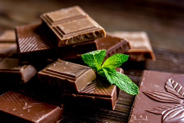 chopped chocolate pieces with mint for dessert wooden desk background