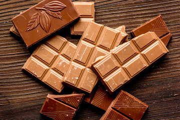 chopped chocolate pieces for dessert wooden desk background top view