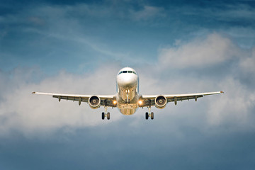 Naklejka premium Front view of a big jet plane taking off on blue cloudy sky background