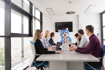 boss dresed as bear having fun with business people in trendy office