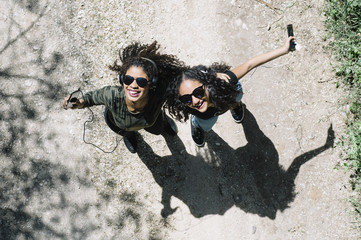 Two latin race friends dancing and having fun outdoors