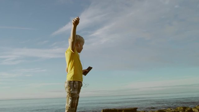 Awesome kid is dancing on a beach