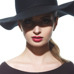 Fashion portrait of a silhouette of a girl in a hat with wide brim with a shadow in front of her eyes.