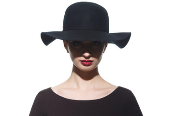 Fototapeta na wymiar Fashion portrait of a silhouette of a girl in a hat with wide brim with a shadow in front of her eyes.