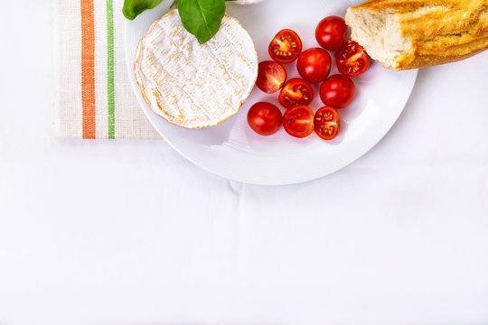 camembert, bread and tomatoes on a plate