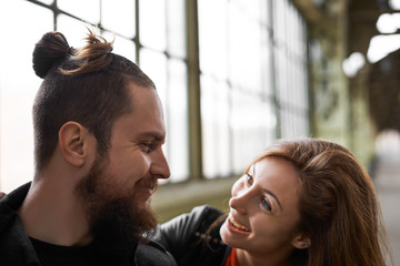 Naklejka premium Happy family meeting. Smiling pretty girl see husband and try to kiss. Appointment of couple friends in big city after many years. Sweet hipsters walking together. Spending time with boyfriend.,