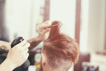 Obraz na płótnie Canvas Barber making modern male hairstyle
