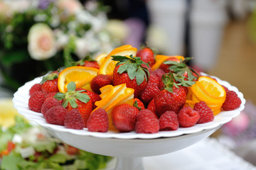 Large plate with strawberries and raspberries on holiday