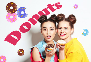 Funny young women with tasty donuts on white background