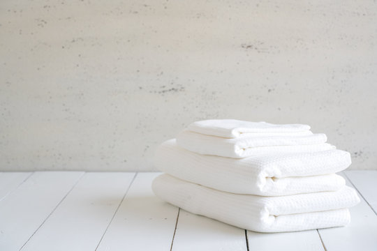 White cotton towels use in spa bathroom on wood background.