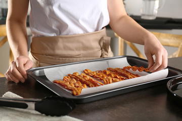 Woman with tray of tasty bacon slices