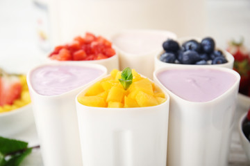 Cups with tasty homemade yogurt, fruit and berries, closeup