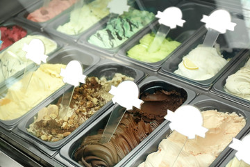 Showcase of different ice cream in metal tubs, closeup