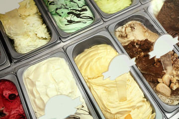 Showcase of different ice cream in metal tubs, closeup