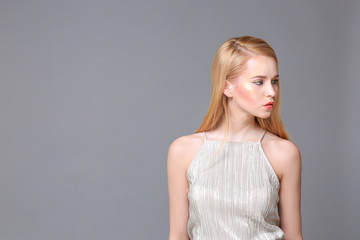 Beautiful young woman on grey background