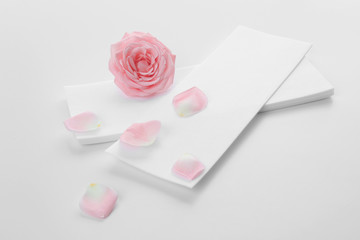 Wax strips for epilation and flower on white background