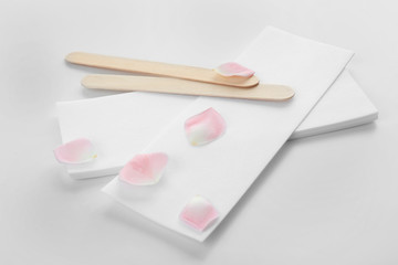 Wax strips for epilation and wooden sticks on white background