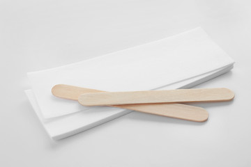 Wax strips for epilation and wooden sticks on white background