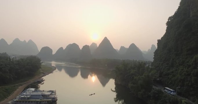 Top view of amaizing famous Yangshuo valley in Guilin, Guangxi, China. Aerial View of beautiful sunrise over bridge and Yulong or Dragon River. Overpopulation concept, beauty in nature