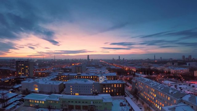 Evening city in winter timelapse. Evening city in winter view from roof timelapse. Panoramic view on the town and roofs under the snow, timelapse. Street night city lights