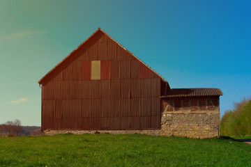 Barn in the middle of the field at sunset