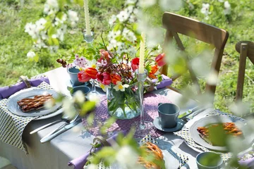 Keuken spatwand met foto Tafelopstelling en kooi met bloemen in de tuin © Africa Studio