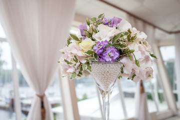 Flower bouquet in glass vase on dining table