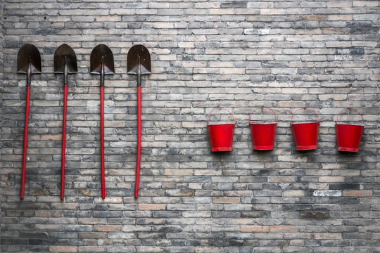 en cas d'incendie, quatre sceaux et quatre pelles accroch&eacute;es &agrave; un mur, 