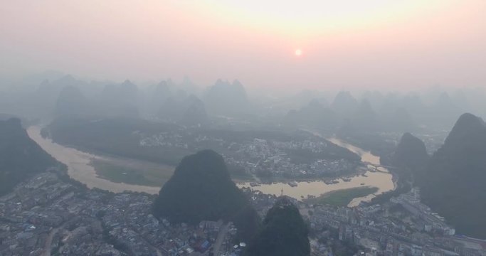 Top view of amaizing famous Yangshuo valley in Guilin, Guangxi, China. Aerial View of beautiful sunrise over Yulong or Dragon River in Yangshuo, China. Overpopulation concept, beauty in nature