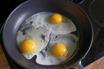 Fried eggs from a hen's egg in a frying pan with yellow yolk