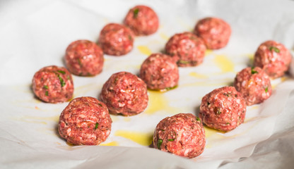 Raw uncooked meatballs on a baking sheet