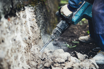 Industrial worker details. Male worker using jackhammer pneumatic drill machinery